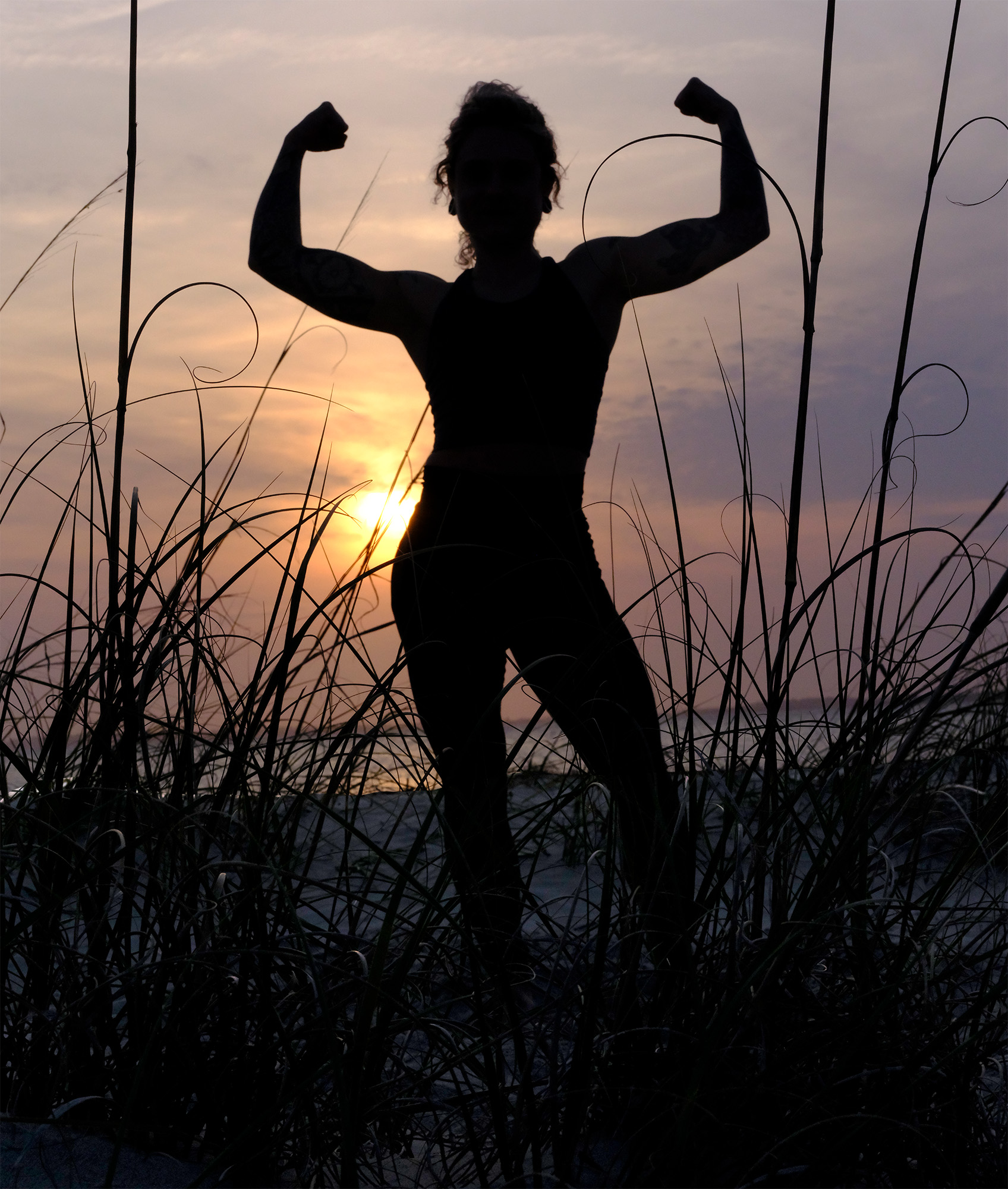 Savanah on the beach at sunset flexing her muscles.